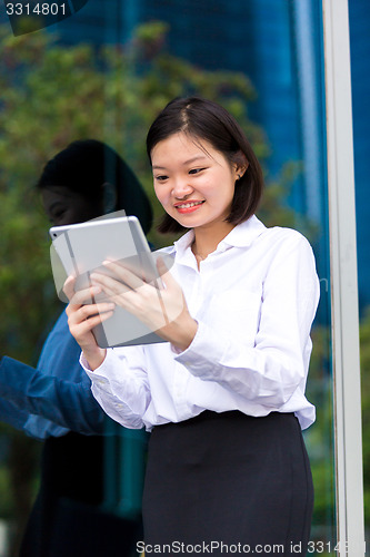 Image of Young Asian female executive using tablet PC