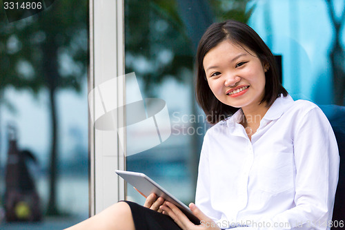 Image of Young Asian female executive using tablet PC