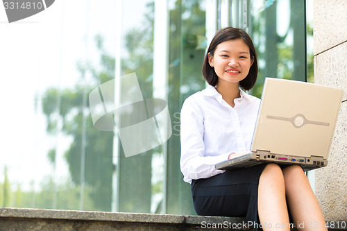 Image of no Young Asian female executive using laptop PC