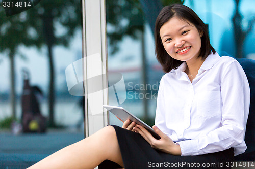 Image of Young Asian female executive using tablet PC