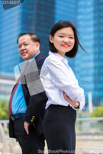 Image of Young Asian female executive and senior businessman in suit portrait