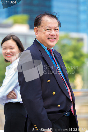 Image of Young Asian female executive and senior businessman in suit portrait