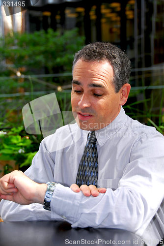 Image of Businessman looking watch
