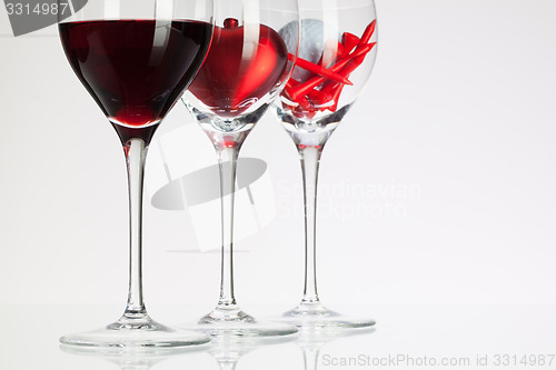 Image of Wine glasses with red wine, heart and golf ball 