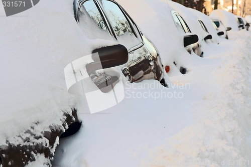 Image of Row of cars covered by deep snow