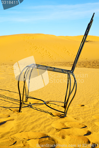 Image of table and seat in desert    yellow sand