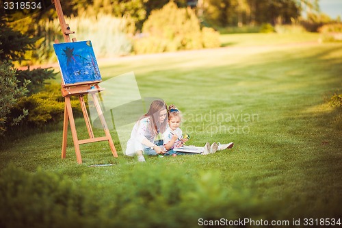 Image of Mother and little daughter paint together