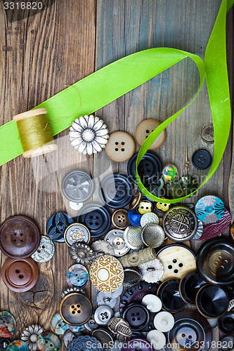 Image of vintage buttons with green ribbon and spool with thread