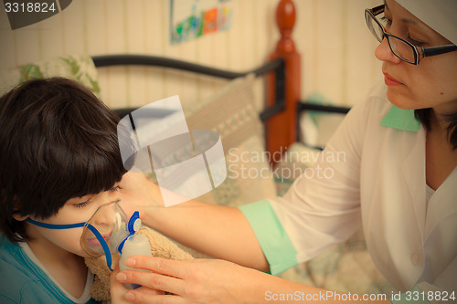 Image of doctor pediatrician spends boy inhalation