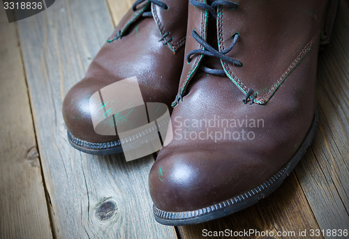 Image of Two brown boots on old boards