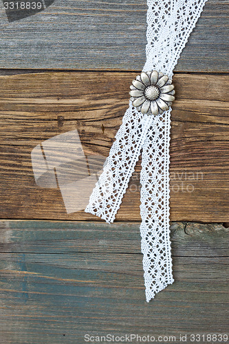 Image of silvery button flower and lace tape