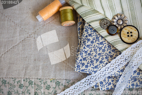 Image of fabric, thread reels, buttons and lace tapes