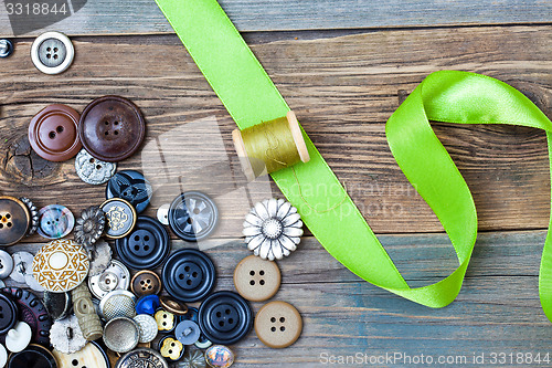 Image of spool with thread, vintage buttons and green tape