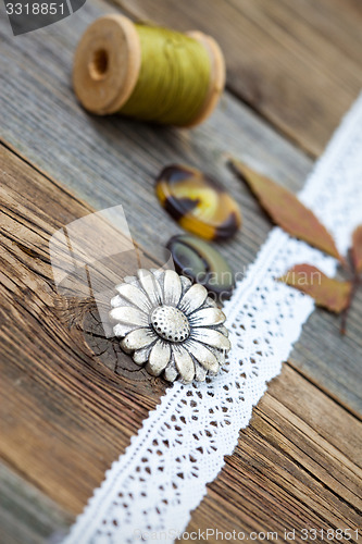 Image of button, lace tape and reel of thread