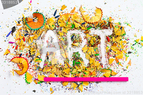 Image of ART word on the background of colored pencil shavings