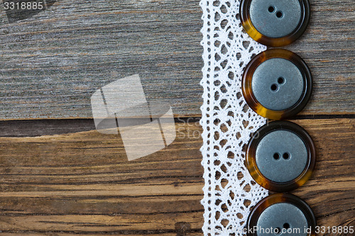 Image of four vintage buttons and antique lace on ancient boards aged tab