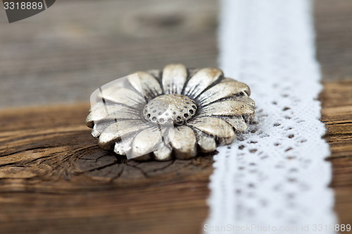 Image of vintage metal button flower and lace ribbon