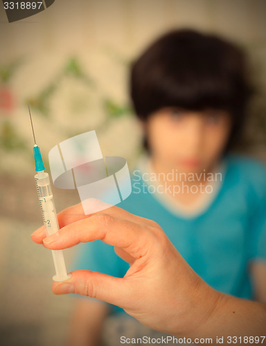 Image of Doctor hand with syringe and child