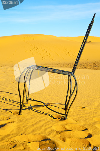 Image of table and seat in desert    yellow sand