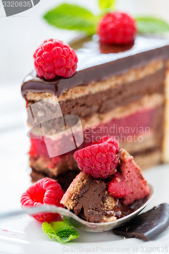 Image of Spoon with chocolate cake and raspberries.