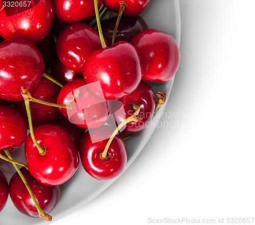 Image of Closeup red sweet cherries in white plate top view