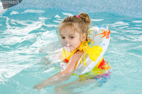 Image of Four-year girl floating in the pool