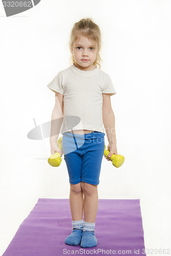 Image of Four-year girl is preparing to raise two dumbbells
