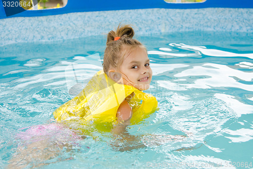 Image of Girl learning to swim in the pool