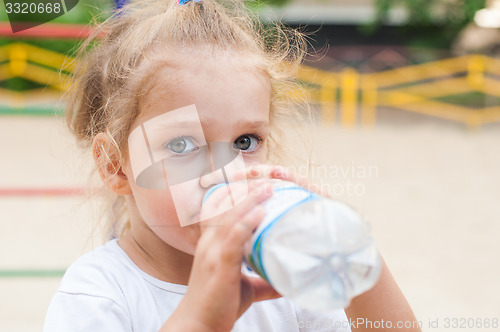 Image of Three year old girl drinks from a bottle