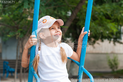 Image of Happy girl riding on a swing