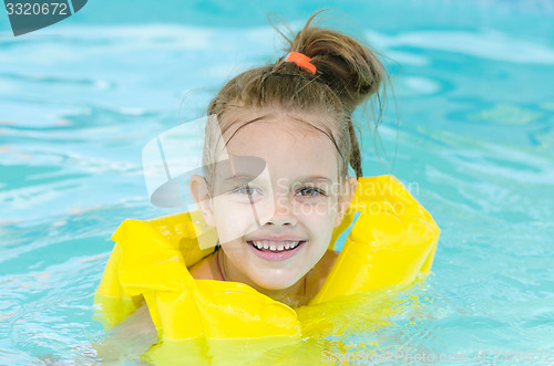 Image of Portrait of smiling girl in a swimming pool