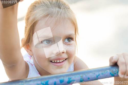 Image of Five-year girl climbs the ladder on playground