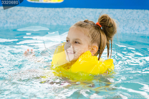 Image of Happy girl swimming in the pool