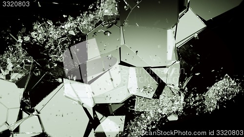 Image of Pieces of smashed cracking glass on black