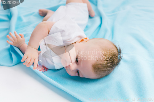 Image of baby lying on a blue blanket