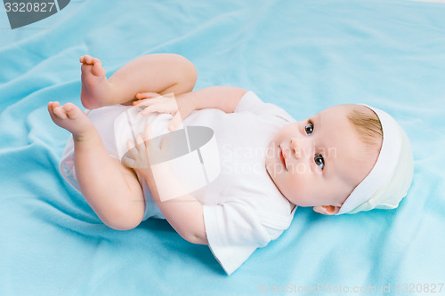 Image of baby in hat lying on a blue blanket