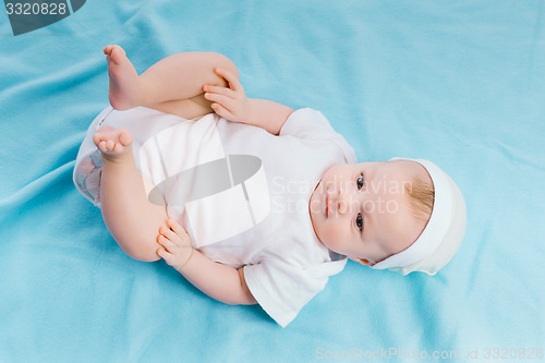 Image of baby in hat lying on a blue blanket