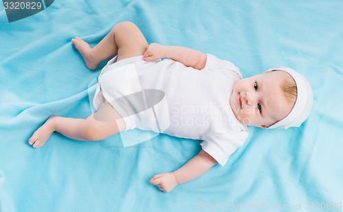 Image of baby in hat lying on a blue blanket
