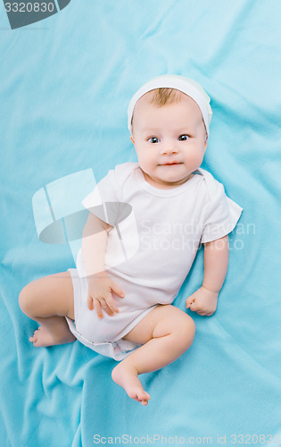 Image of baby in hat lying on a blue blanket