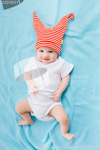 Image of toddler in a striped hat on a blue blanket