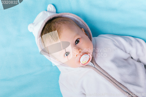 Image of baby in the hood on a blue blanket