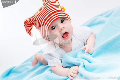 Image of toddler in a striped hat on a blue blanket