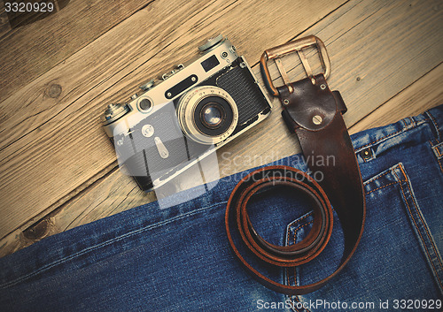 Image of old blue jeans, vintage leather belt and ancient rangefinder cam