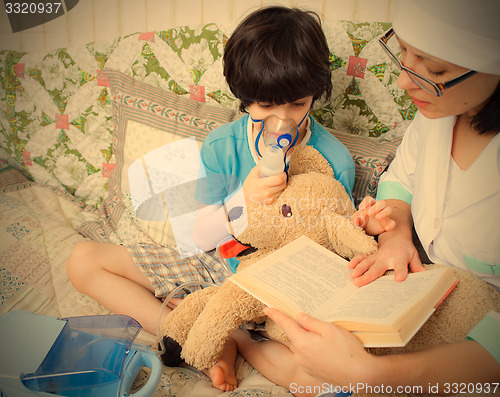 Image of doctor pediatrician spends boy inhalation session