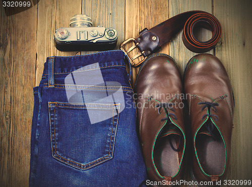 Image of Still life with rangefinder camera, brown boots, leather belt an