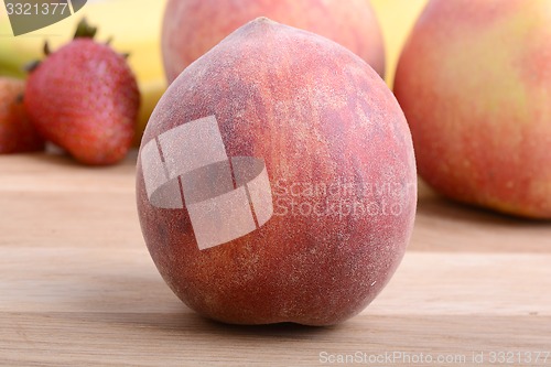 Image of peach,  apple and strawberry on wooden plate 