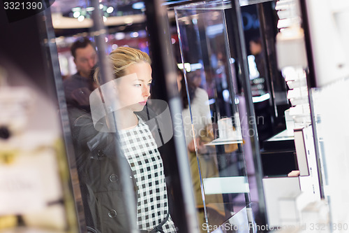 Image of Beautiful woman standing in front of showcase.