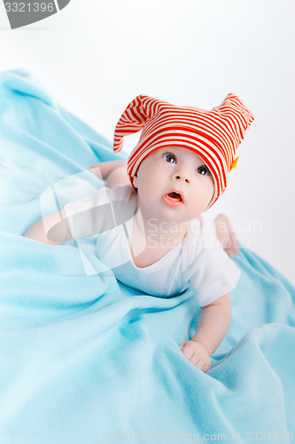 Image of toddler in a striped hat on a blue blanket