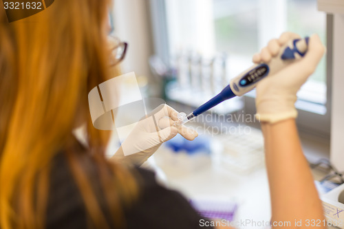Image of Young scientist pipetting.