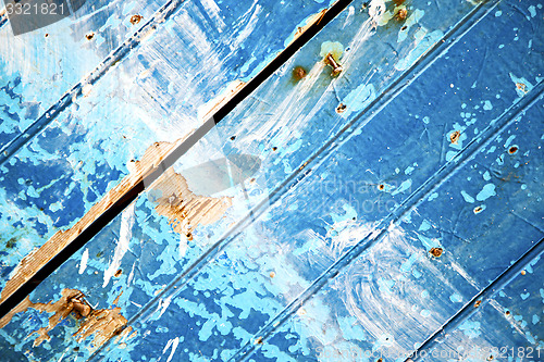 Image of stripped paint in the blue  and rusty nail